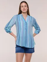 Blusa de gasa de la marca Zac & Rachel, con estampado de rayas verticales en tonos azules, celestes y lilas. Presenta cuello a la base con escote en V, abertura central con botones, detalle plisado en el frente y mangas de largo regulable con presilla y botón.