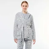Bata de forro polar suave con estampado de leopardo en tonos grises. Presenta un diseño con capucha, cierre frontal cruzado con lazo ajustable en la cintura y bolsillos laterales.
