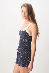 Pijama corto de color azul marino con pequeño estampado floral blanco, compuesto por una musculosa con detalles de encaje en el escote y un short con cordón ajustable en la cintura.