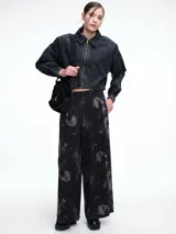 Pantalón de corte amplio y recto, confeccionado en lyocell con estampado orgánico efecto lavado en tonos beige y gris. Presenta tiro alto con cintura elastizada y bolsillos laterales.