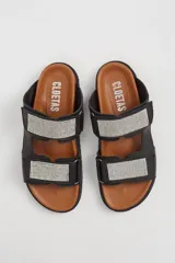 Sandalias planas negras de cuero vacuno con doble tira con apliques de strass y ajuste con velcro.