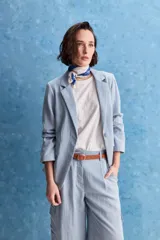 Blazer celeste de corte clásico, con solapas de muesca, cierre frontal de un botón y bolsillos delanteros de vivo. De manga larga y diseño estructurado.