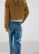 Jeans de denim azul de tiro medio, corte wide leg y diseño de pernera ancha con terminación deshilachada en el bajo.