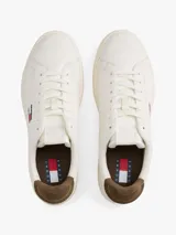 Zapatillas de estilo tenis confeccionadas en piel napa blanca, con diseño de corte bajo y cordones. Presentan un panel a contraste en el talón en color marrón y el parche distintivo de Tommy Jeans en el lateral.