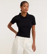 Blusa polo beige de manga corta, confeccionada en tejido canelado de rib de algodón con elastano, que proporciona un ajuste cómodo y una caída ajustada.