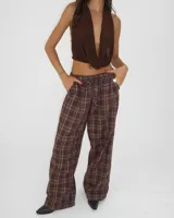 Pantalón de corte ancho con cintura elástica y bolsillos laterales, estampado a cuadros en tonos marrones.