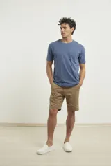 Remera de manga corta color verde grisáceo, con cuello redondo y un bolsillo aplicado en el pecho.