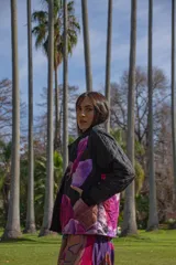 Chaqueta negra con estampado de hojas en tonos rosa, violeta y marrón. Diseño acolchado con cuello clásico y cierre frontal con botones.