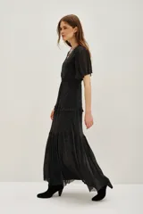 Vestido midi de color negro con acabado brillante, escote en V cruzado, mangas cortas con volados y falda con niveles fruncidos.