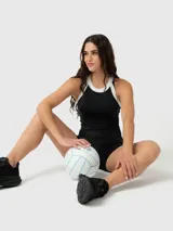 Musculosa deportiva con cuello halter, diseño bicolor en negro y blanco, confeccionada en tejido técnico elástico.