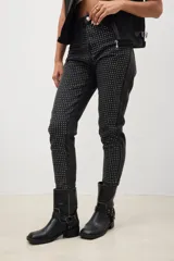 Pantalón de jean negro con corte skinny y tachas plateadas.