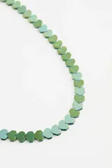 Collar corto de metal con dijes en forma de corazón en tonos verdes.