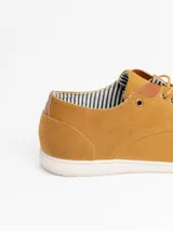 Zapato acordonado de estilo casual confeccionado en material sintético tipo gamuza color azul marino, con suela plana de goma en tono claro y detalles de cuero en el talón y la lengüeta.