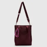 Bolso tipo tote de la marca Bubba, modelo Ontario Regular, color bordó, confeccionado en cuero PU. Cuenta con compartimento principal espacioso con cierre, bolsillos exteriores, asas de mano y correa larga ajustable e intercambiable con inscripciones de la marca. Incluye un llavero decorativo de cuerda en tonos rosados.