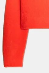 Jersey de punto de cuello redondo y manga larga, con acabado en rib en puños y ruedo.