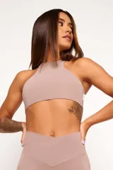 Top deportivo de cuello alto, confeccionado en tejido de poliamida y elastano. Presenta un diseño minimalista, ajuste al cuerpo y forro interno para mayor soporte.