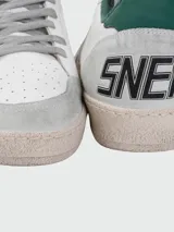 Championes Golden Goose modelo Ball Star, color blanco con detalles en verde y gris. Presentan la estrella distintiva de la marca en el lateral y efecto desgastado en la suela.