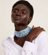 Pañuelo triangular de satén color celeste con estampado paisley en blanco.