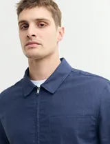Campera de estilo harrington color azul oscuro, con cierre frontal, cuello camisero y bolsillo frontal tipo parche.