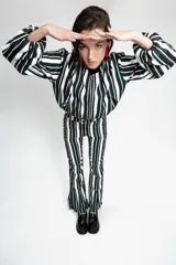 Campera tipo bomber corta, con cierre frontal, cuello a la base, bolsillos ojal y mangas largas abullonadas. Presenta un diseño estampado a rayas verticales en tonos blanco, negro y verde.