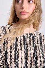 Top de punto crochet con diseño de rayas verticales en negro y beige, cuello redondo y textura calada con motivos florales.