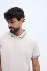 Chomba de piqué en color negro, de manga corta, con cuello y puños tejidos con líneas a contraste. Presenta cierre frontal parcial con botones y pequeño logo bordado en el pecho.
