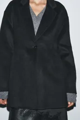 Blazer Zara de corte entallado confeccionada en mezcla de lana. Presenta cuello con solapa de muesca, manga larga y cierre frontal con un solo botón.