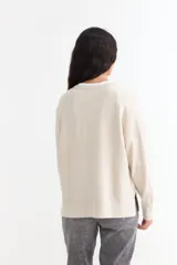 Sweater de tejido de punto color azul marino, con cuello abierto tipo polo y tajos laterales en el ruedo. Presenta mangas largas con puños acanalados y un corte holgado.