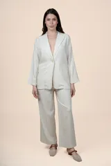 Blazer de lino y viscosa color beige con calce relajado, solapa clásica, cierre de un botón y bolsillos delanteros con solapa.