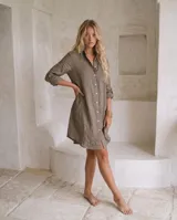 Vestido camisero de lino color marrón, de corte recto y largo midi, con mangas largas abotonadas, cuello camisero y cierre frontal con botones de nácar.