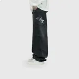 Jean de corte ultra baggy color negro con efecto lavado. Presenta un diseño de estrella grande bordada en el bolsillo trasero y costuras reforzadas.