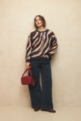 Cartera tipo bandolera de diseño trenzado, con correa ajustable y desmontable de cinta técnica. Cuenta con cierre superior y detalle de aplique metálico en el frente.