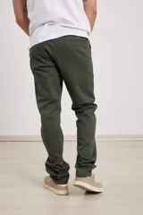 Pantalón chino de hombre color verde oscuro, corte slim, confeccionado en algodón con elastano, con triple pespunte en las costuras y botones al tono.
