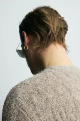 Jersey de punto con acabado cepillado, cuello redondo y manga larga. Presenta un diseño de trenzas verticales en toda la prenda y un corte relajado.