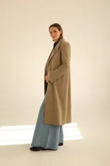 Tapado largo de paño en color beige, con solapas clásicas, cierre frontal de dos botones y corte recto estructurado.