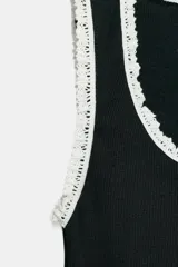 Top de algodón negro, sin mangas, con escote redondo y detalle de vivos a contraste en tejido tipo encaje blanco en el cuello y las sisas.