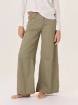 Pantalón ancho de algodón color verde oliva, con corte holgado desde la cadera hasta el tobillo. Presenta pinzas debajo de la rodilla, bordado de monograma en el bolsillo delantero y pespuntes a contratono.