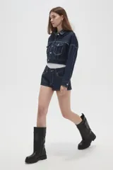 Short de jean negro engomado, de tiro medio y corte ajustado, con bolsillos laterales y traseros y costuras pespunteadas en contraste.