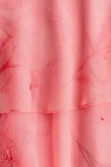 Vestido corto de gasa liviana rosado con estampado floreado, escote redondo pronunciado y breteles finos ajustables. Presenta un volado asimétrico amplio en la cintura y bajo asimétrico.