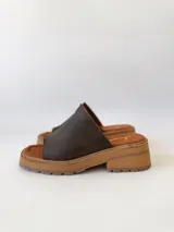 Sandalias de cuero color chocolate, con tira ancha sobre los dedos y suela de goma con plataforma.