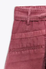 Shorts color rosa viejo, de tiro medio y corte holgado, con cintura elástica y cinturón de lazo ajustable.