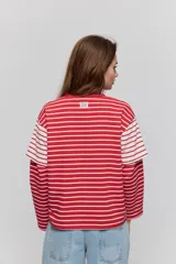 Remera de manga corta con diseño a rayas horizontales azules y blancas, corte relajado y cuello redondo.