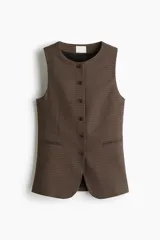 Chaleco largo sin mangas, con cuello redondo y cierre frontal de botones. Presenta un estampado de pata de gallo en tonos marrones y negros, bolsillos delanteros ribeteados y abertura en la parte trasera inferior.