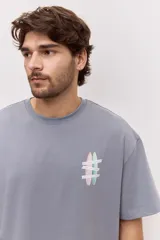 Remera oversize blanca de manga corta, con corte amplio y estampa gráfica pequeña en el pecho.