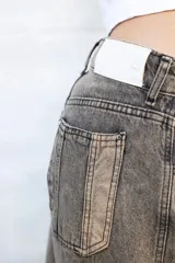 Jean de mujer color gris oscuro con efecto acid wash, de corte holgado y tiro bajo.