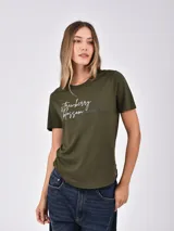 Remera verde militar de manga corta, con cuello redondo y bajo asimétrico. Presenta un estampado frontal con la frase "strawberry blossom" en blanco y detalles gráficos en negro.