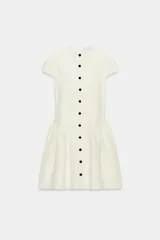 Vestido corto blanco de encaje, con cuello redondo, manga corta y bajo evasé con frunces. Cuenta con fila de falsos botones negros delanteros a contraste y cierre trasero con cremallera oculta.