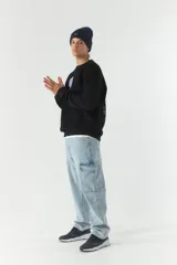 Buzo de felpa color crudo con cuello redondo y estampado frontal con el texto 'Good Vibes' y el logo de la marca Mistral. Tiene un parche con el logo de la marca en la manga izquierda.