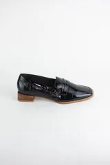 Mocasín clásico de cuero con textura croco acharolada, con taco cuadrado bajo símil madera.