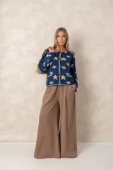 Pantalón de corte recto y tiro alto, confeccionado en tela con caída fluida, color marrón, con bolsillos laterales y pinzas frontales.